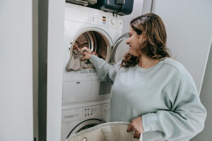 positive woman loading washing machine